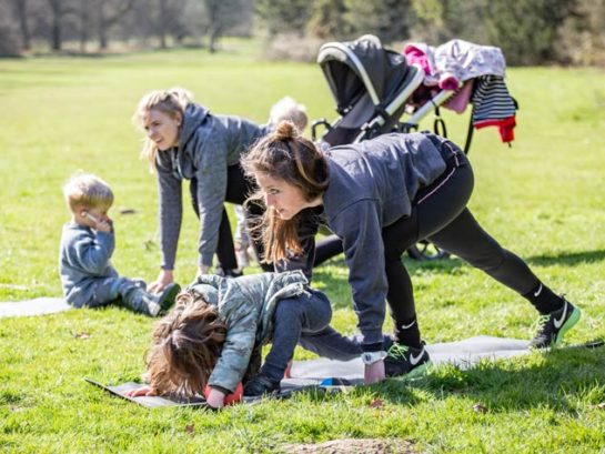 Mother and child enjoying yoga outside in a park in Bury St Edmunds