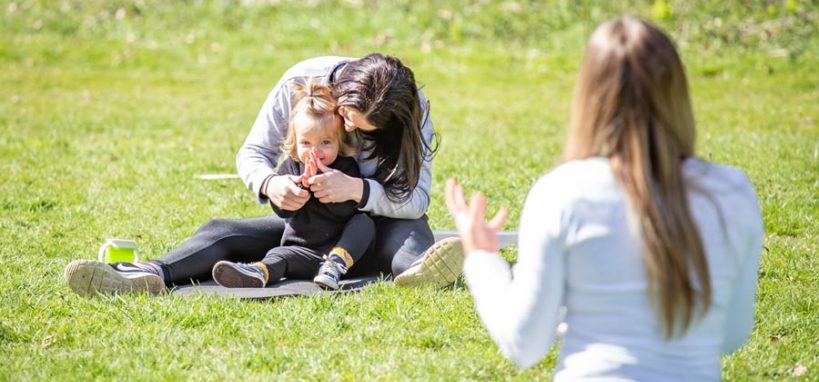 A mother holds her child on a yoga mat