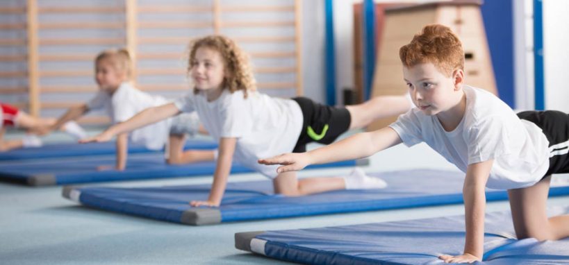 Children performing the bird dog yoga pose