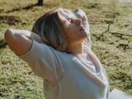 A lady stretching outside in the morning sun